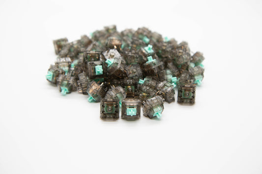 Close-up shot of a pile Durock Linear-62 g mechanical keyboard switches featuring gray transparent housing and teal stems
