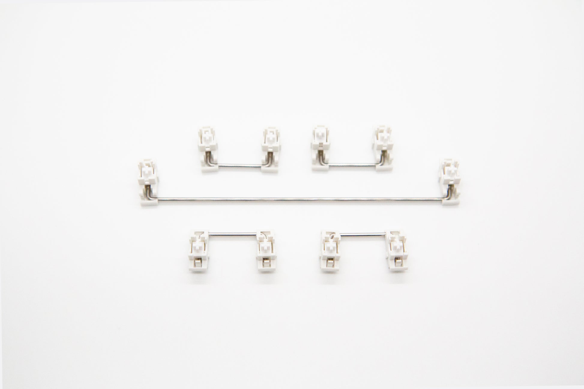 Overhead shot of PCB mounted white mechanical keyboard Durock stabilizer kit in 7u configuration with screws and washers