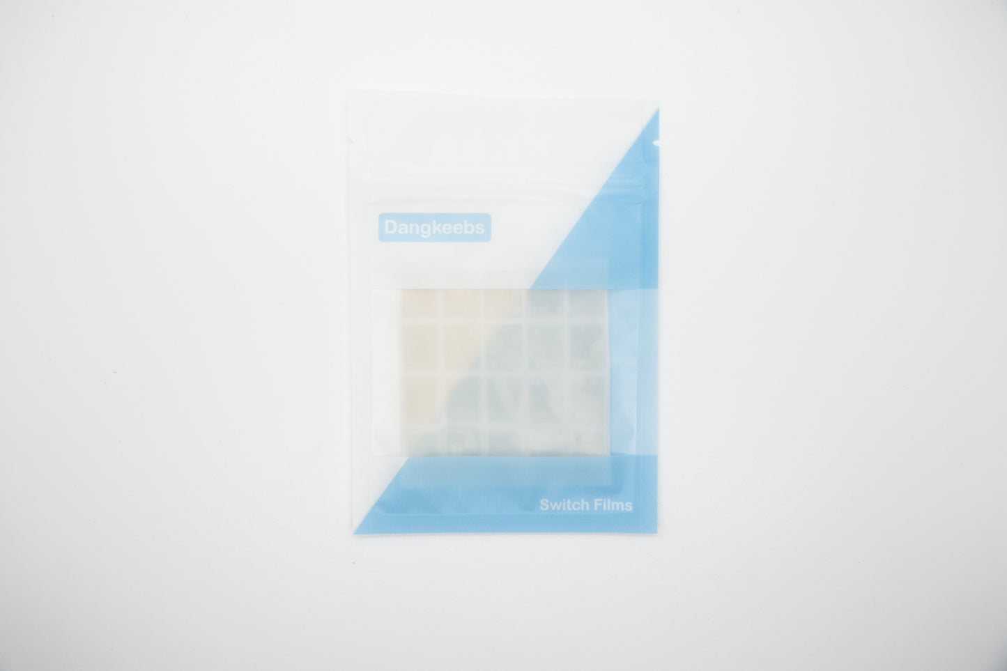 Overhead shot of silicone blend mechanical keyboard switch films in white and blue packaging pouch on a white background
