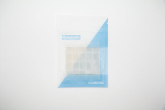 Overhead shot of silicone blend mechanical keyboard switch films in white and blue packaging pouch on a white background