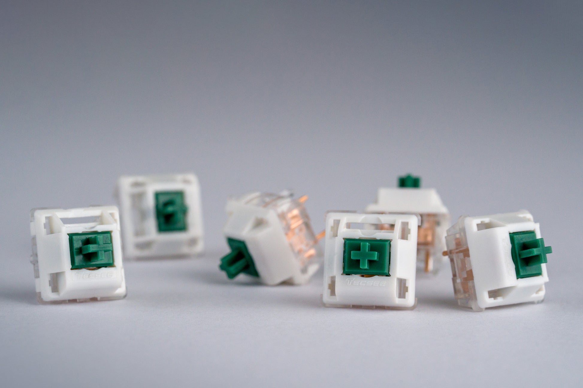 Close-up shots of BBN Linear mechanical keyboard switches featuring white and transparent housing and green stems