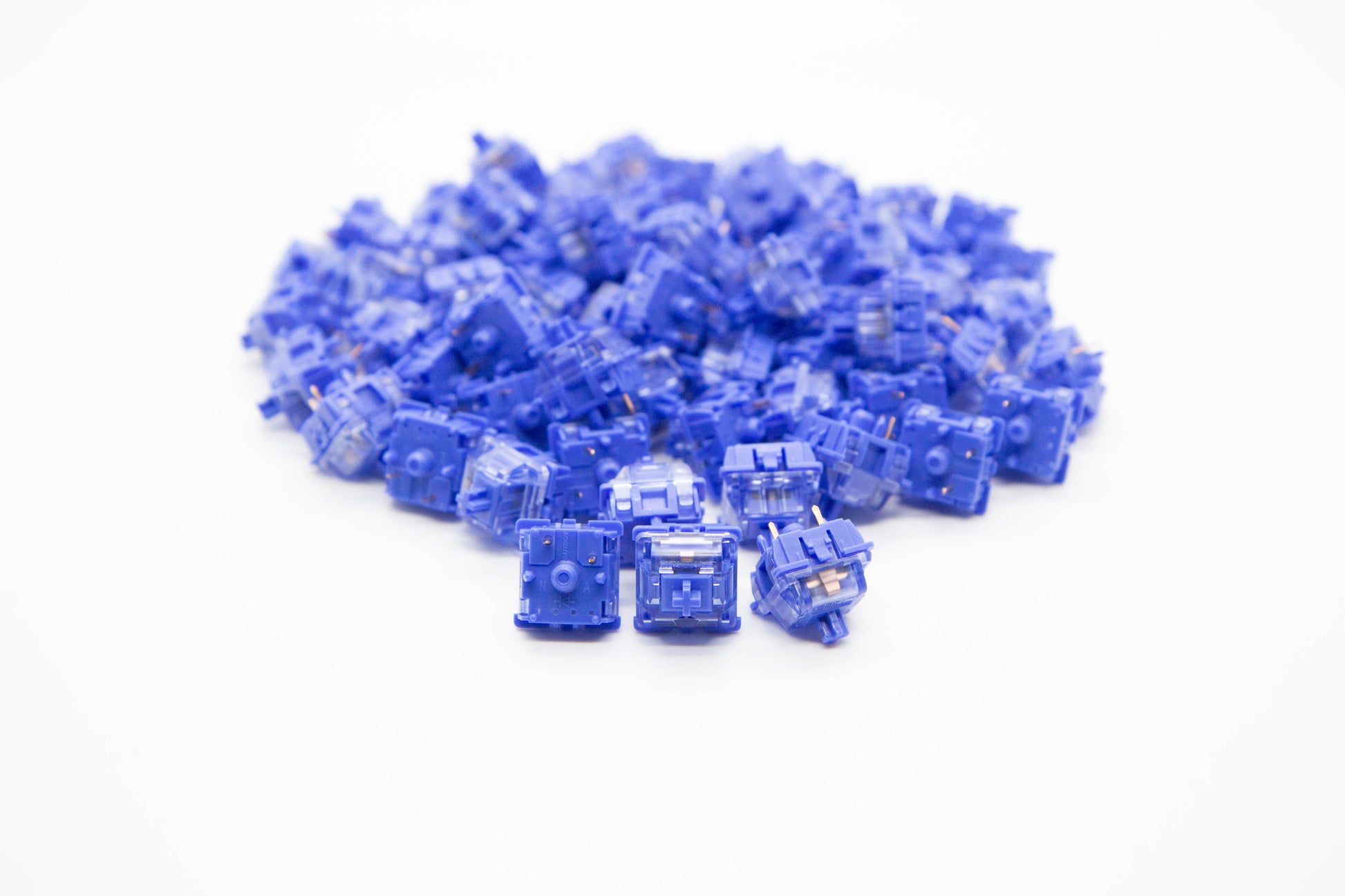 Close-up shot of a pile of Gateron CJ mechanical keyboard switches featuring blue housing and blue stems