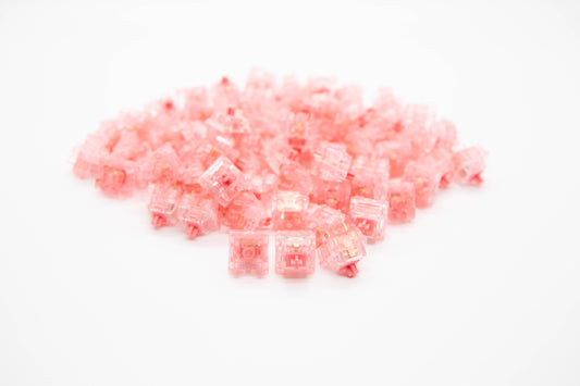 Close-up shot of a pile of Strawberry mechanical keyboard switches featuring pink transparent housing and pink stems