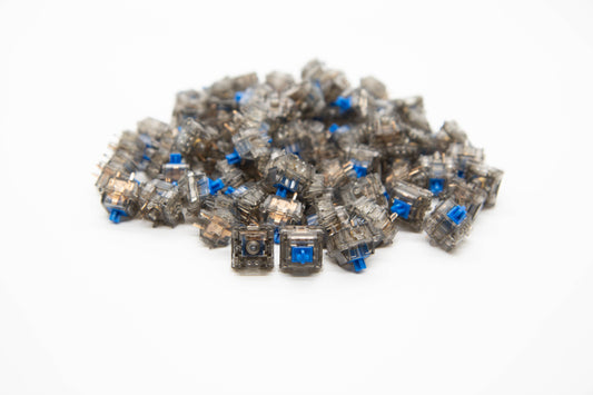 Close-up shot of a pile of Durock Daybreak mechanical keyboard switches featuring gray transparent housing and blue stems