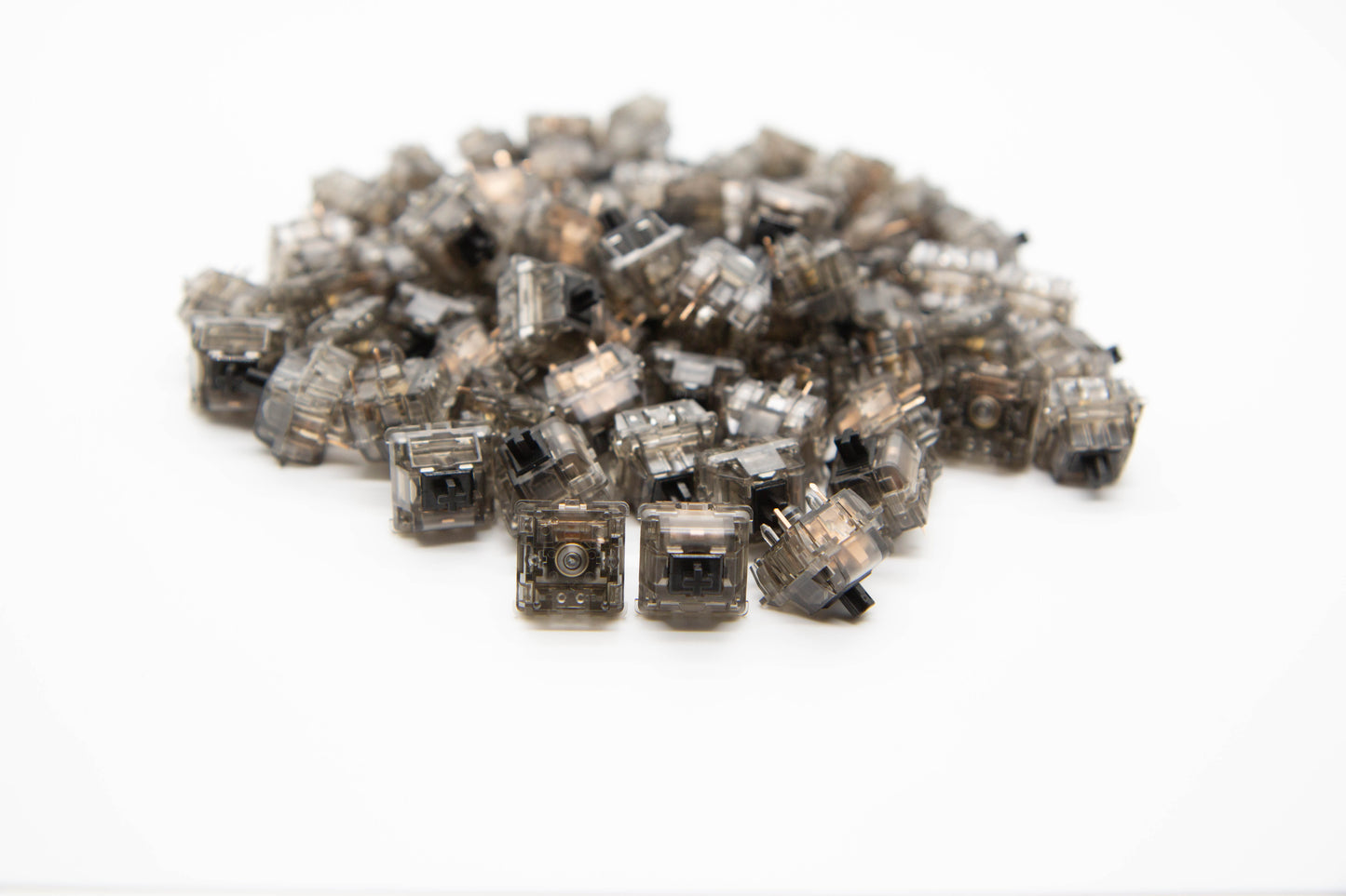 Close-up shot of a pile of Durock Linear-78 g mechanical keyboard switches featuring gray transparent housing and black stems