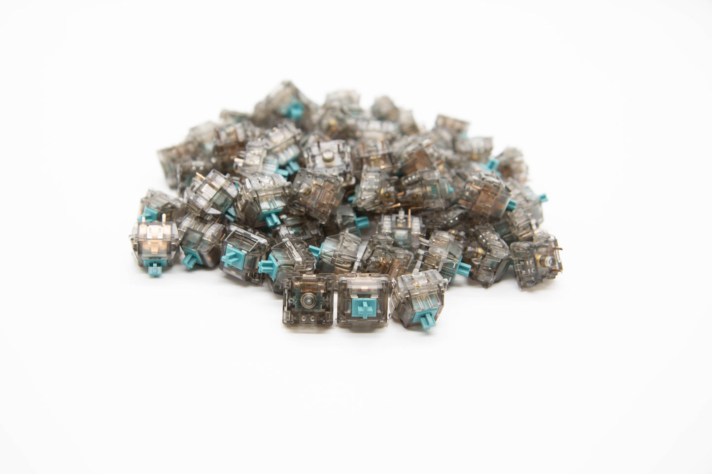 Close-up shot of a pile of Durock T1 mechanical keyboard switches featuring gray transparent housing and dark teal stems