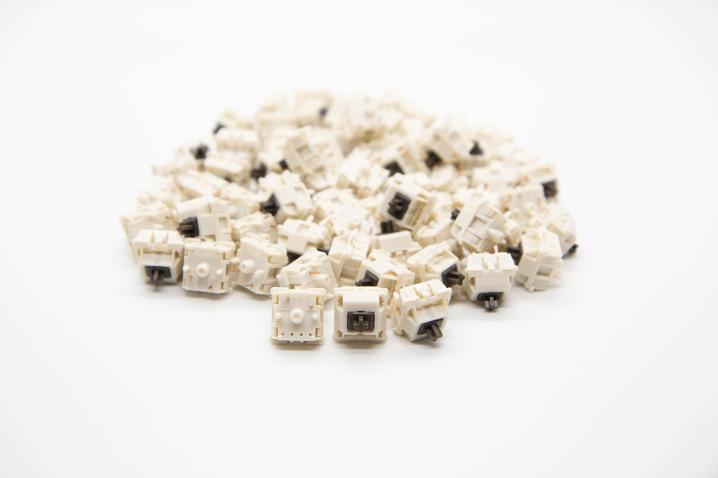 Close-up shot of a pile of Koala themed mechanical keyboard switches featuring white housing and dark brown stems