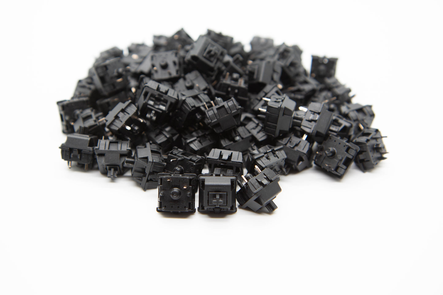 Close up shot of a pile of Cherry Hyperglide Black mechanical keyboard switches featuring black housing and black stems