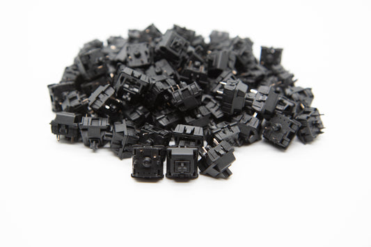 Close up shot of a pile of Cherry Hyperglide Black mechanical keyboard switches featuring black housing and black stems