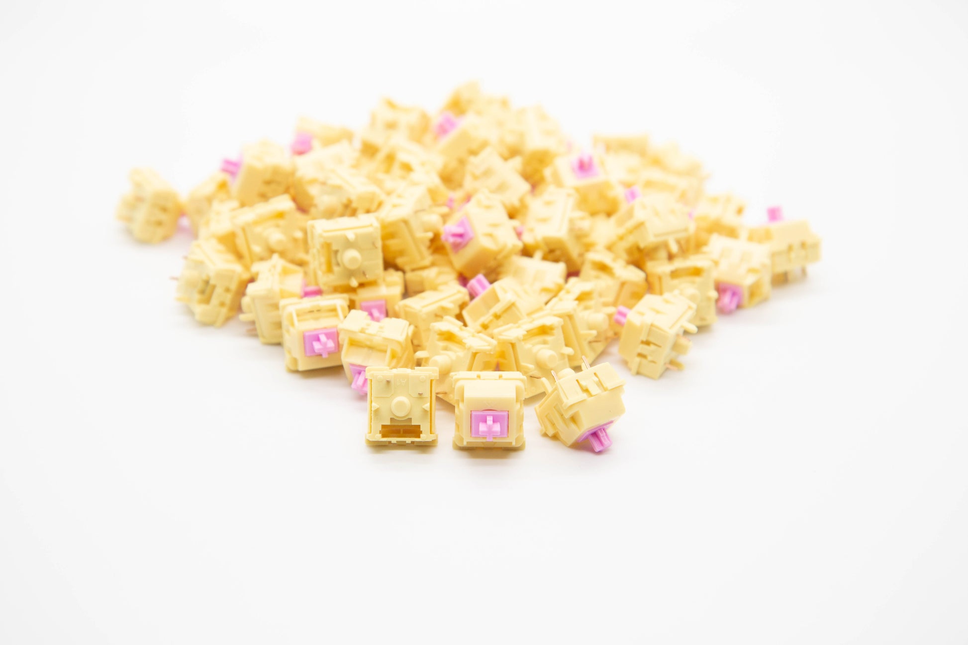 Close-up shot of a pile of KTT Mallo mechanical keyboard switches featuring yellow housing and pink stems