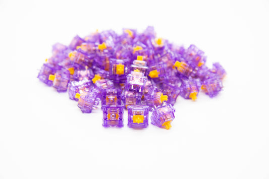 Close-up shot of a pile of Tecsee Ice Grape mechanical keyboard switches featuring purple transparent housing and orange stems
