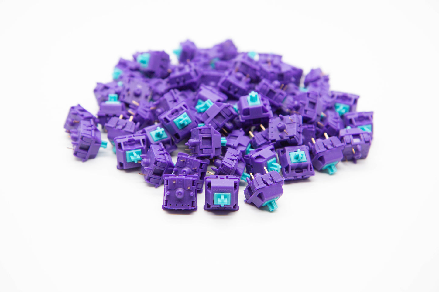 Close-up shot of a pile of KBDFans x MITO x Gateron Laser - 60g mechanical keyboard switches featuring purple housing and teal stems