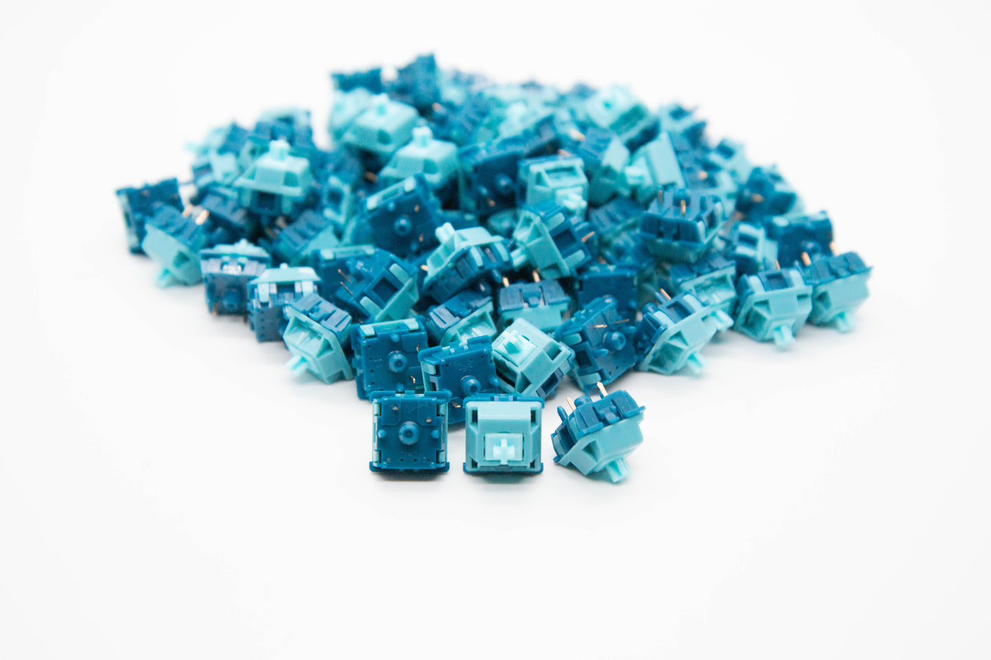 Close-up shot of a pile of Poseidon mechanical keyboard switches featuring dark and light blue housing and light blue stems