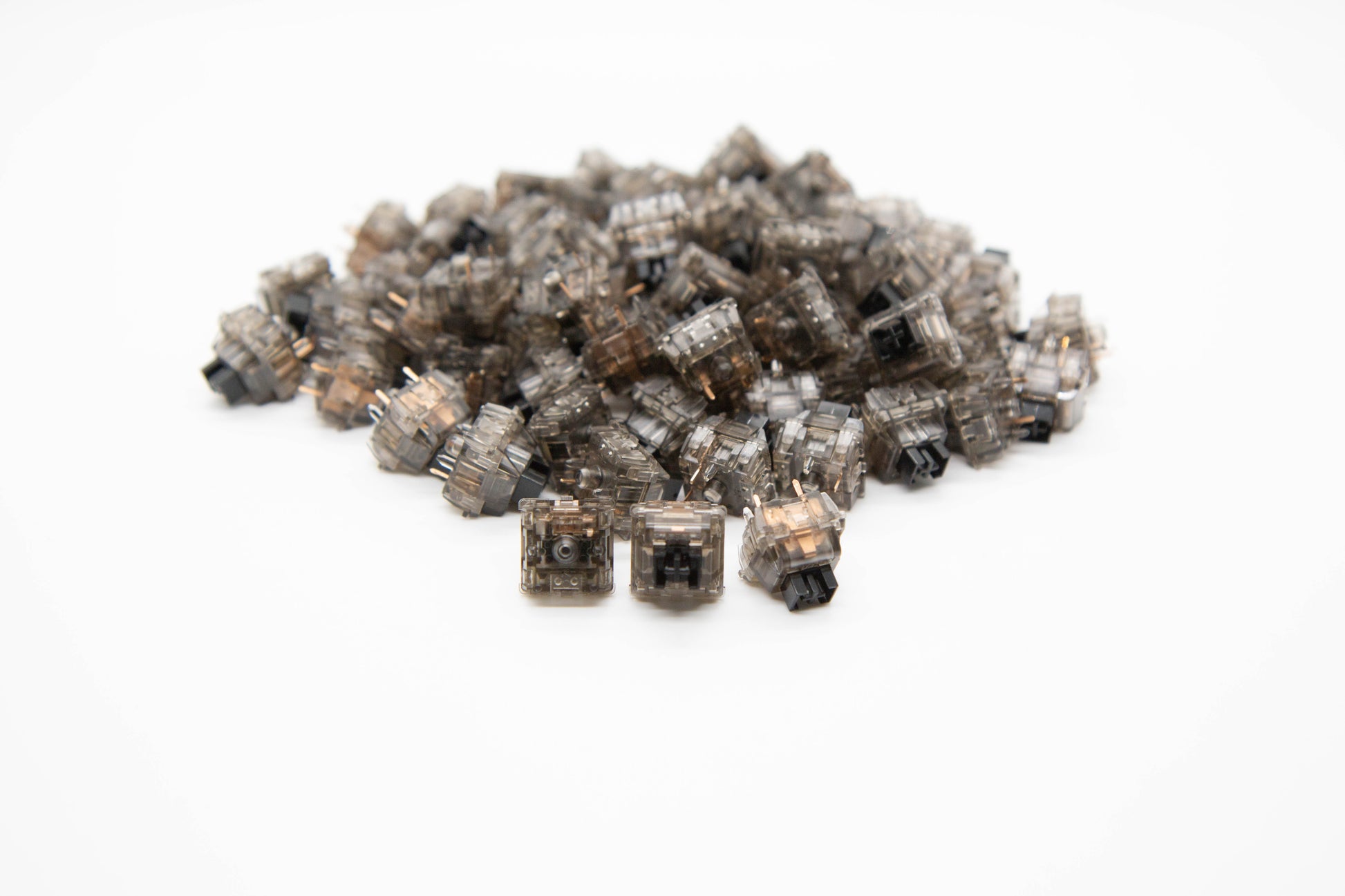 Close-up shot of a pile of Gateron Box Ink V2 mechanical keyboard switches featuring black transparent housing black stems