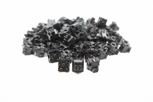 Close-up shot of a pile of KTT Monochrome Onyx mechanical keyboard switches featuring black housing and black stems