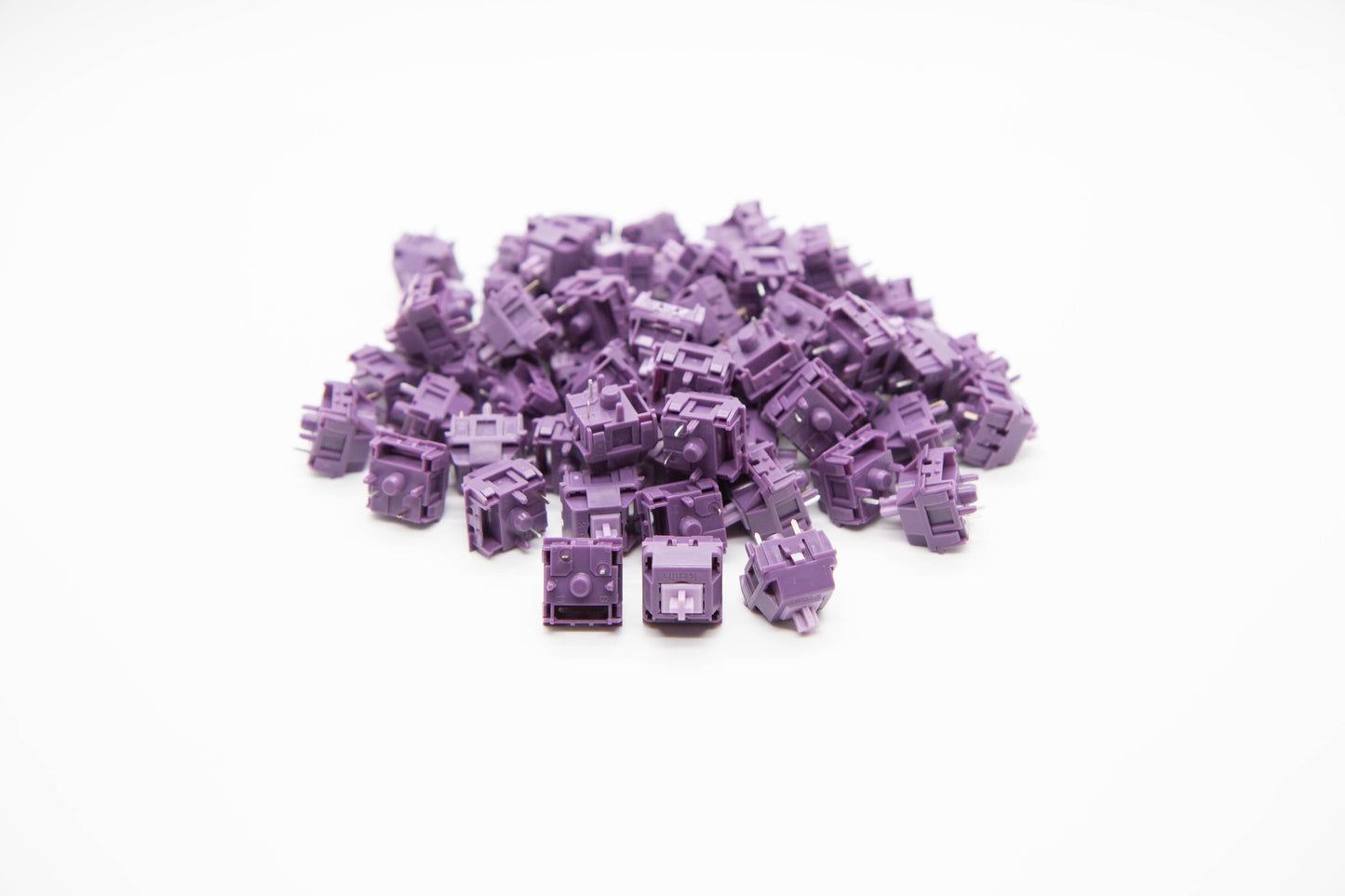 Close-up shot of a pile of Purple Potato mechanical keyboard switches featuring purple housing and light purple stems