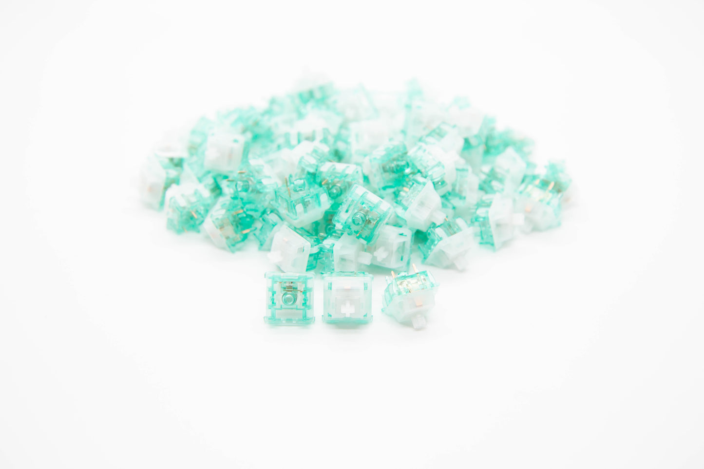 Close-up shot of a pile of Tecsee Jadeite mechanical keyboard switches featuring transparent teal and clear housing and clear stems