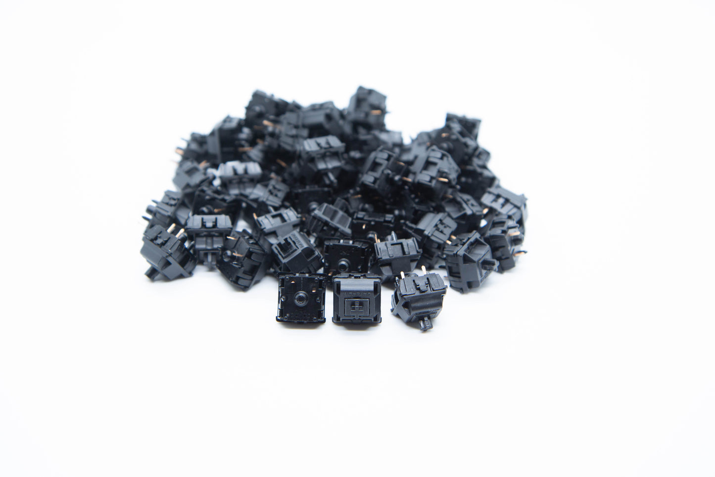 Close-up shot of a pile of Gateron Oil King mechanical keyboard switches featuring black housing and black stems