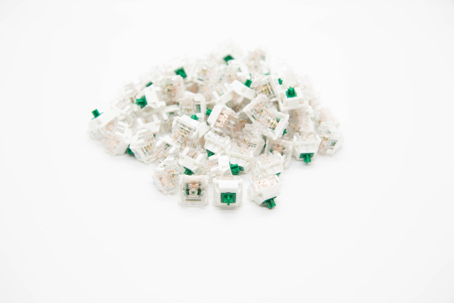 Close up shot of a pile of BBN Linear mechanical keyboard switches featuring white and transparent housing and green stems