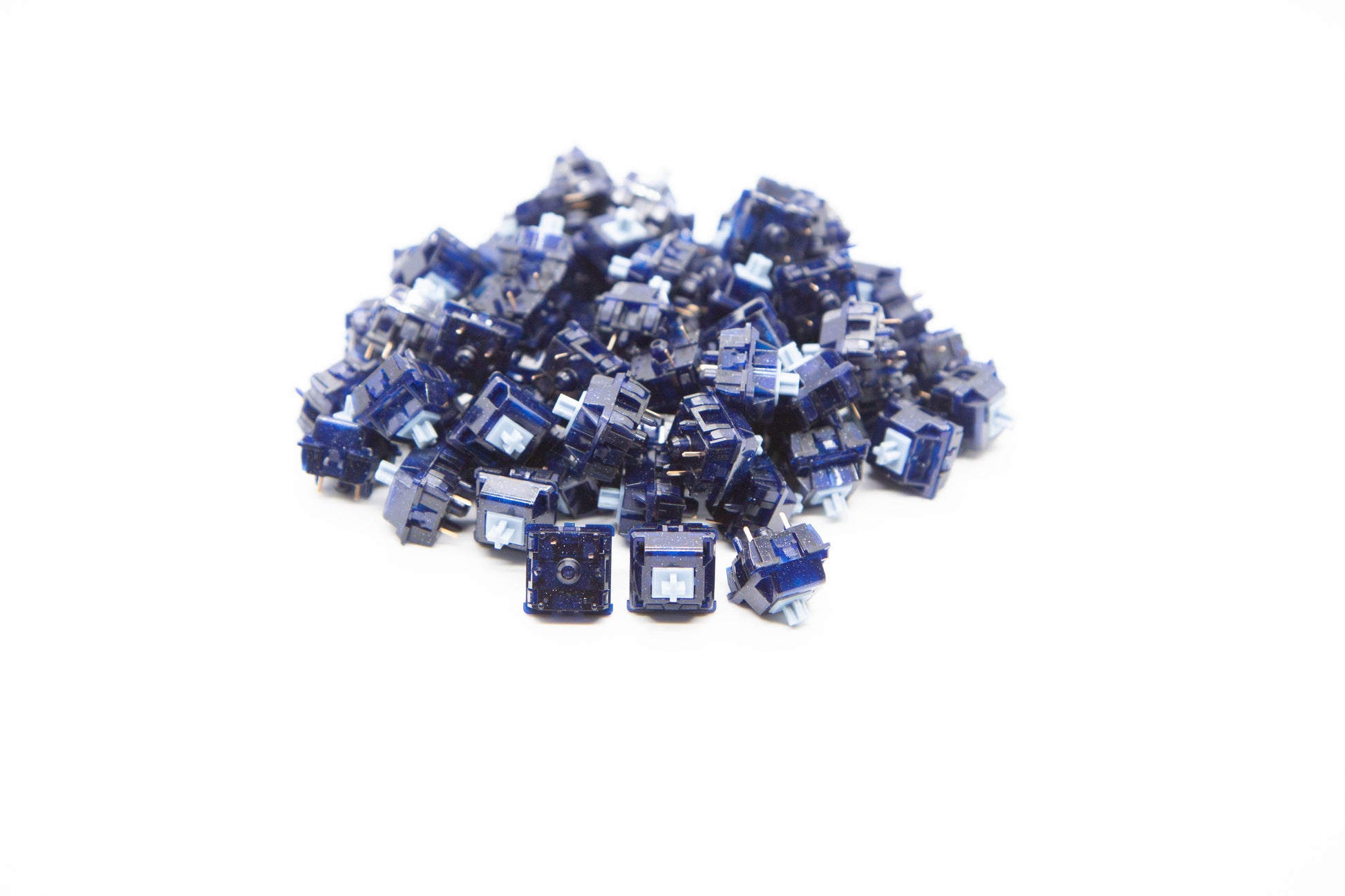 Close-up shot of a pile of Hoshizora mechanical keyboard switches featuring dark blue galaxy housing and baby blue stems