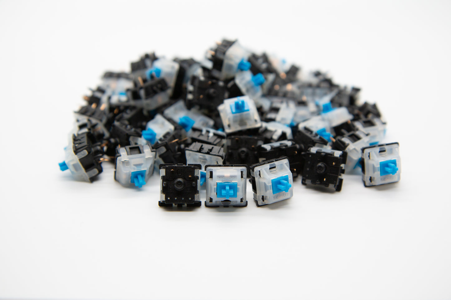 Close-up shot of a pile of Gateron Blue mechanical keyboard switches featuring black and white housing and blue stems