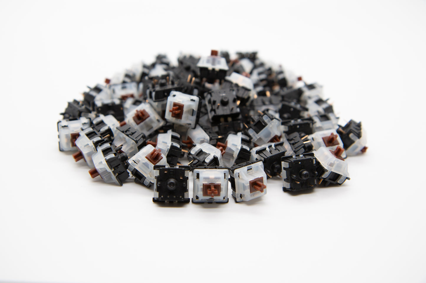 Close-up shot of a pile of Gateron Brown mechanical keyboard switches featuring black and white housing brown stems