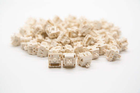 Close-up shot of a pile of Novelkeys x Kailh Cream mechanical keyboard switches featuring cream-colored housing and cream-colored stems