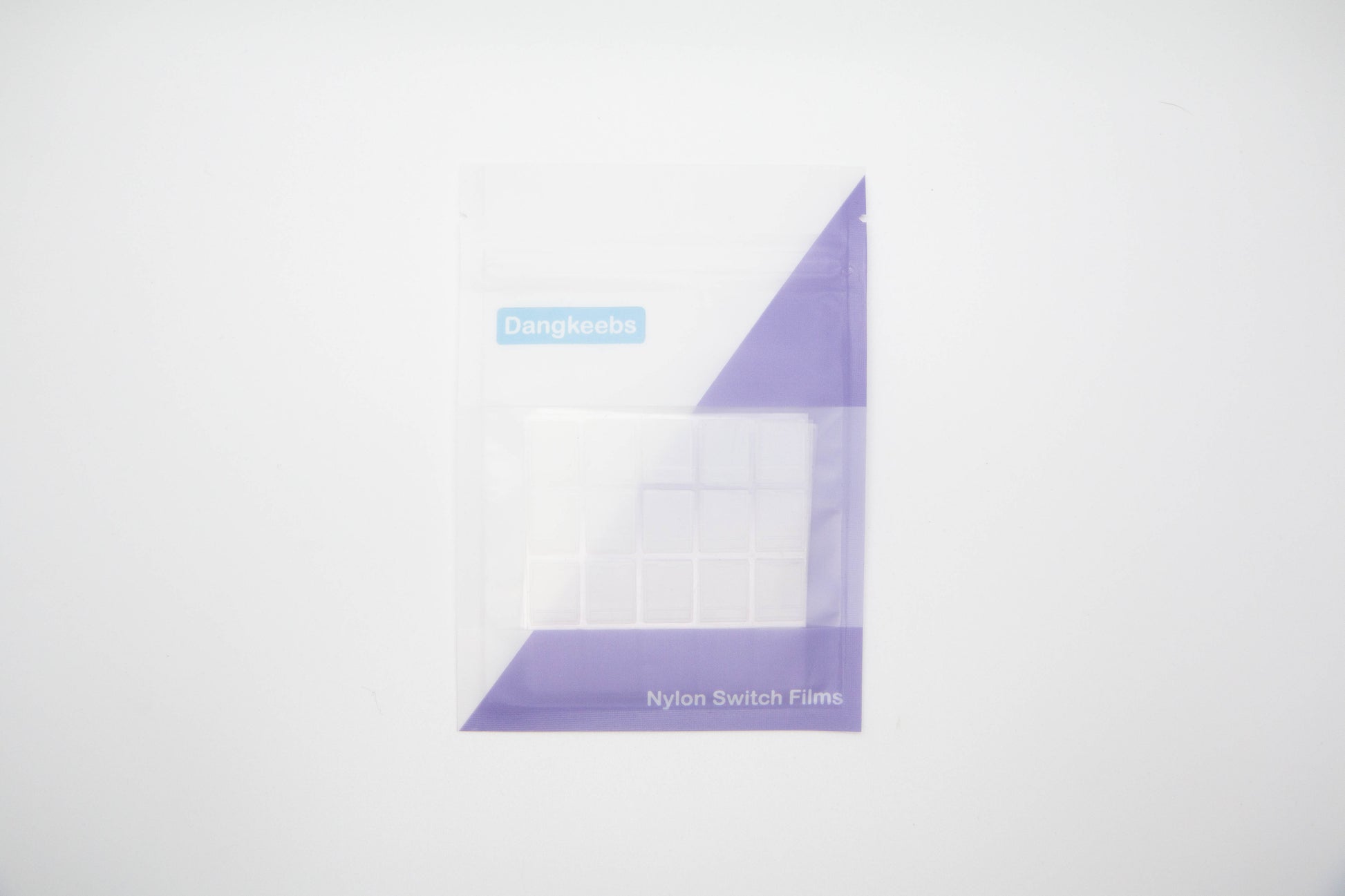 Overhead shot of nylon blend mechanical keyboard switch films in white and purple packaging pouch on a white background