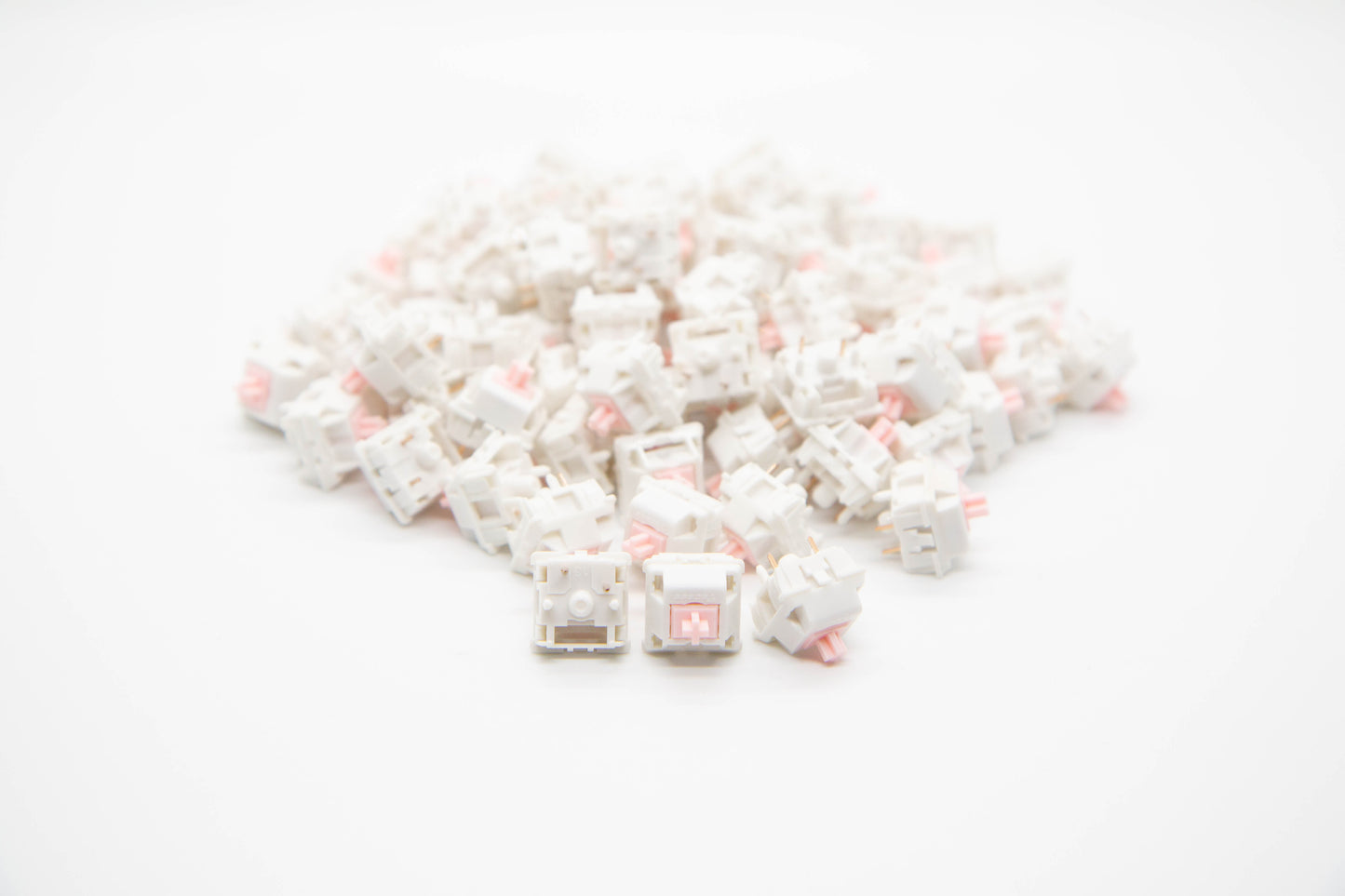 Close-up shot of a pile of Strawberry Milk - Tactile themed mechanical keyboard switches featuring white housing and light pink stems